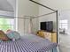 Bright bedroom featuring a four-poster bed, flatscreen TV, and closet for ample storage at 8361 S Upham Way # 209, Littleton, CO 80128
