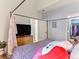 Spacious bedroom features a cozy bed, large closet, and dresser with flat screen television at 8361 S Upham Way # 209, Littleton, CO 80128