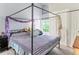 Bedroom with a four-poster bed, large window, and closet at 8361 S Upham Way # 209, Littleton, CO 80128