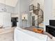 Bright living room featuring a spiral staircase, vaulted ceiling, and kitchen access at 8361 S Upham Way # 209, Littleton, CO 80128