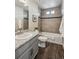 Bathroom with tiled shower and tub, gray vanity with light countertop, and wood-look flooring at 8095 E 128Th Pl, Thornton, CO 80602