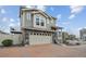 Attractive two-story home with a gray exterior, stone accents, a brick driveway, and an upper-level deck at 8095 E 128Th Pl, Thornton, CO 80602