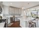 Modern kitchen featuring stainless steel appliances, gray cabinetry, a white countertop island with seating, and stylish backsplash at 8095 E 128Th Pl, Thornton, CO 80602