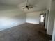 Empty bedroom with carpet flooring, ceiling fan, light walls, and door to ensuite bathroom at 2005 W 86Th Ave, Denver, CO 80260