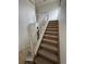Carpeted staircase featuring white railing, leading to the second floor of the home at 2005 W 86Th Ave, Denver, CO 80260