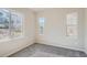 Sunlit bedroom with gray carpet and multiple windows offering natural light and neighborhood views at 2560 Wesley Ln, Lafayette, CO 80026