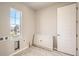 Bright laundry room features a large window, modern tile flooring, and utility connections at 2560 Wesley Ln, Lafayette, CO 80026