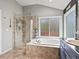 Spacious bathroom featuring a separate shower and tub, lots of natural light, and modern fixtures at 5497 W Prentice Ct, Littleton, CO 80123