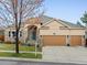 Charming single-Gathering home featuring a three-car garage, stone accents, and a manicured front yard at 5497 W Prentice Ct, Littleton, CO 80123