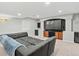 Spacious basement game room featuring comfortable seating and a large entertainment center at 5497 W Prentice Ct, Littleton, CO 80123