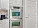 Stainless steel double oven appliances, white cabinets and beige tile backsplash at 5497 W Prentice Ct, Littleton, CO 80123