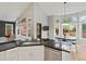 Open-concept kitchen with stainless steel appliances, black granite countertops, and seamless view into dining area at 5497 W Prentice Ct, Littleton, CO 80123