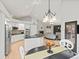 Open kitchen with stainless steel appliances, black countertops and adjacent living area at 5497 W Prentice Ct, Littleton, CO 80123