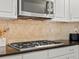 White cabinets, black countertops and stainless steel gas range top at 5497 W Prentice Ct, Littleton, CO 80123