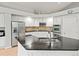 Modern kitchen featuring stainless steel appliances, granite countertops, white cabinets, and plenty of workspace at 5497 W Prentice Ct, Littleton, CO 80123