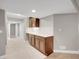 Finished basement bar area with updated counter, cabinetry, and tiled backsplash at 6525 S Abilene St, Englewood, CO 80111