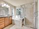 Well-lit bathroom features double sink vanity, soaking tub, and glass enclosed shower at 6525 S Abilene St, Englewood, CO 80111