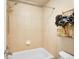 Full bathroom with tiled shower-over-tub, neutral wall color, and decorative wall shelving at 6525 S Abilene St, Englewood, CO 80111
