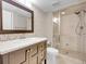 Updated bathroom with new vanity, mirror, patterned wallpaper, and glass-enclosed shower at 6525 S Abilene St, Englewood, CO 80111
