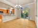 Bright dining area with chandelier, wood floors, and access to outdoor green space at 6525 S Abilene St, Englewood, CO 80111