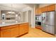 Gourmet kitchen featuring stainless steel appliances, granite countertops, and wood cabinets at 6525 S Abilene St, Englewood, CO 80111