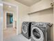 Convenient laundry room featuring modern washer and dryer units, storage shelf, and access to the second floor at 6525 S Abilene St, Englewood, CO 80111
