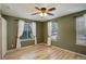 Spacious bedroom with hardwood floors, ceiling fan, and natural light from three windows at 2840 Canyon Crest Ln, Highlands Ranch, CO 80126