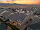 An aerial view shows the back of a house with mountain views during a vibrant sunset at 11412 Autumn Moon St, Littleton, CO 80125