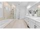 Bright bathroom featuring double vanity, bathtub and glass enclosed shower at 11412 Autumn Moon St, Littleton, CO 80125
