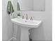 Bathroom pedestal sink with modern faucet, green towel, and decorative plant under a frameless mirror at 11412 Autumn Moon St, Littleton, CO 80125