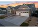 Charming home with a two-car garage, gray siding, tasteful stone accents, and tidy landscaping at 11412 Autumn Moon St, Littleton, CO 80125