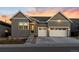 Beautiful exterior elevation showcasing a two-car garage, gray siding, stone accents, and manicured front yard at 11412 Autumn Moon St, Littleton, CO 80125