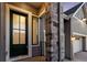 Inviting entryway with a stylish front door, stone pillar, and modern exterior lighting at 11412 Autumn Moon St, Littleton, CO 80125