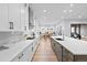 Bright kitchen boasts white cabinets, stainless appliances, and a quartz countertop island at 11412 Autumn Moon St, Littleton, CO 80125