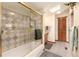 Bathroom featuring a tile shower with glass door, a skylight, and wooden cabinets at 23136 Kiowa Rd, Indian Hills, CO 80454