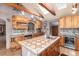 Kitchen with island, tile counters, wine fridge, and skylights providing natural light at 23136 Kiowa Rd, Indian Hills, CO 80454