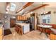 Spacious kitchen with wooden beams, island, stainless steel appliances, and breakfast nook at 23136 Kiowa Rd, Indian Hills, CO 80454