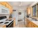 Bright kitchen with light wood cabinets, tile countertops, and access to dining area at 23136 Kiowa Rd, Indian Hills, CO 80454