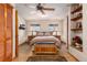 Bright main bedroom with hardwood floors, decorative ceiling fan and well-lit shelving at 23136 Kiowa Rd, Indian Hills, CO 80454