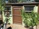 A view of the shed with a brown door, windows, and snow blower at 23136 Kiowa Rd, Indian Hills, CO 80454