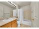 Clean bathroom with a single vanity, ample mirror, toilet and shower-tub combination with white shower curtain at 15112 E 116Th Pl, Commerce City, CO 80603