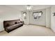 A cozy bedroom features neutral carpet, a futon, and decoratively framed windows at 15112 E 116Th Pl, Commerce City, CO 80603