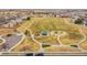 Aerial view of a community park featuring a playground, walking paths, green space, and a sheltered picnic area at 15112 E 116Th Pl, Commerce City, CO 80603