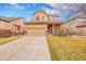 Charming two-story home featuring a well-maintained lawn and a spacious driveway leading to the garage at 15112 E 116Th Pl, Commerce City, CO 80603