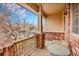 Cozy front porch featuring brick columns, a small table, and a charming seating area at 15112 E 116Th Pl, Commerce City, CO 80603