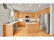 Well-lit kitchen features stainless steel appliances, an island, and light wood cabinets at 15112 E 116Th Pl, Commerce City, CO 80603