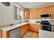 Modern kitchen featuring stainless steel appliances, ample counter space, and light wood cabinets at 15112 E 116Th Pl, Commerce City, CO 80603