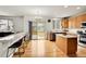 Bright kitchen with hardwood floors, an island, bar seating, and a sliding glass door at 15112 E 116Th Pl, Commerce City, CO 80603