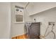 Modern laundry room with a sleek washer and hardwood flooring beneath the window at 15112 E 116Th Pl, Commerce City, CO 80603