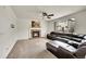 Bright living room features a cozy brick fireplace and a comfortable leather sectional sofa at 15112 E 116Th Pl, Commerce City, CO 80603